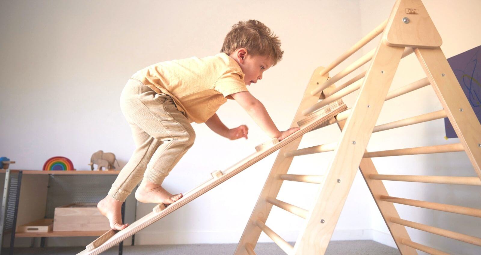 child climbing on organic pikler triangle