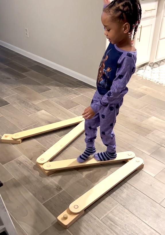 child walking on w shaped balance beam