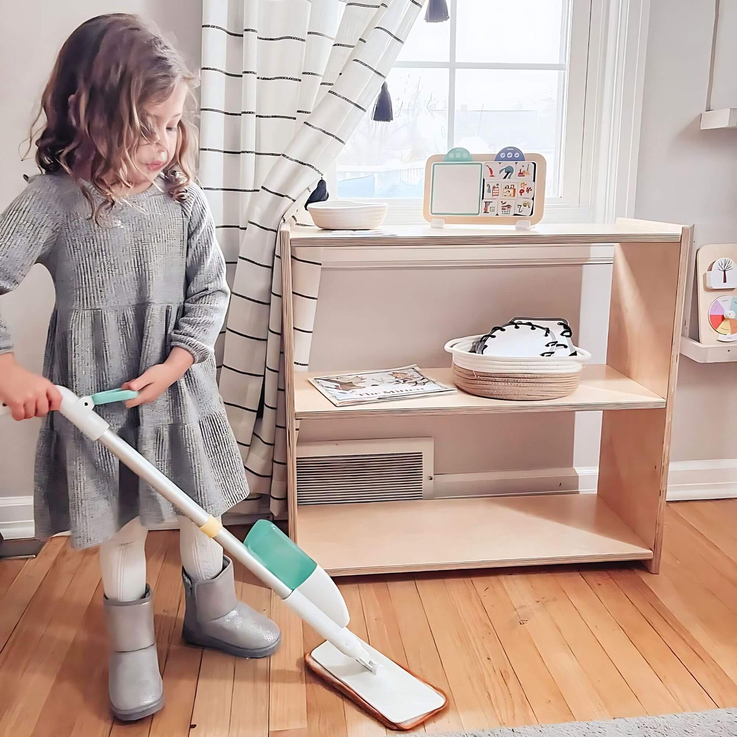 montessori shelf with child mopping