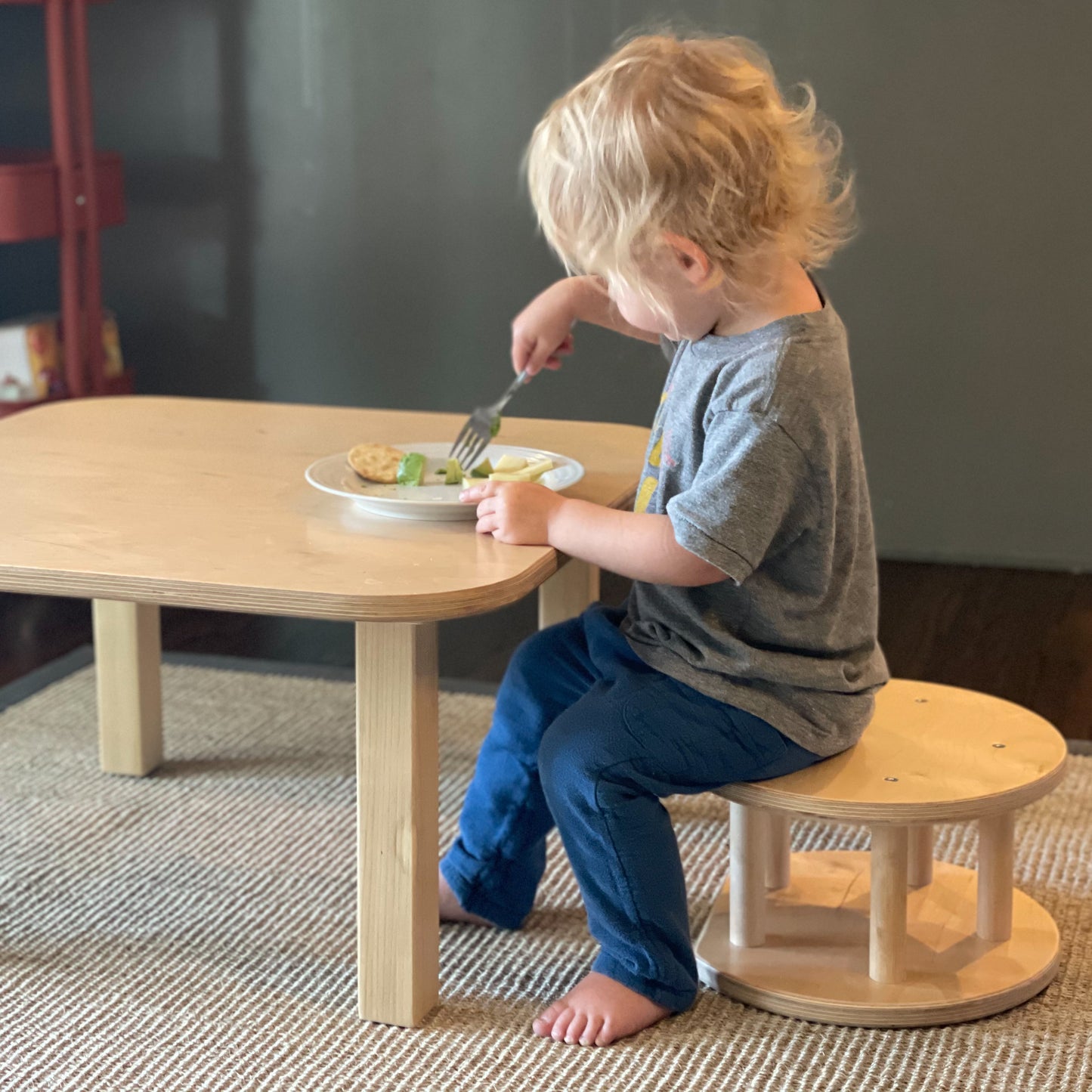 child sitting on wooden stool as a weaning table and chair set