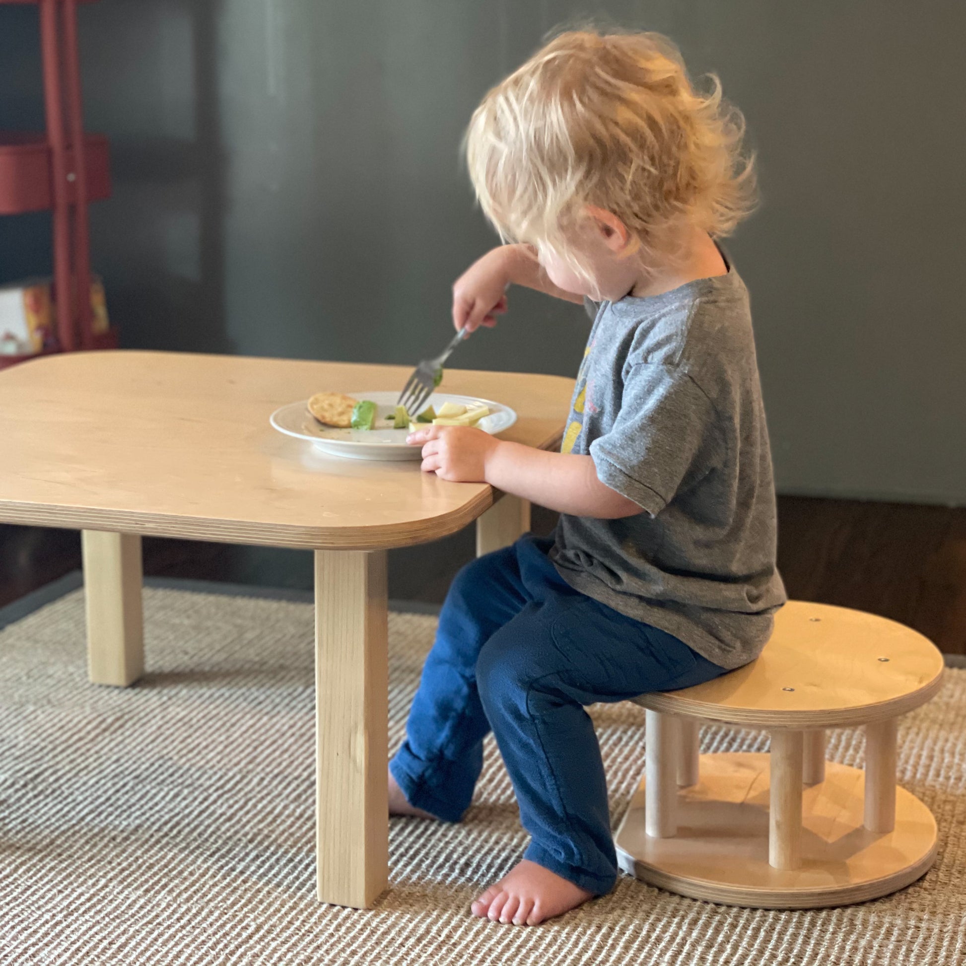 child sitting on wooden stool as a weaning table and chair set