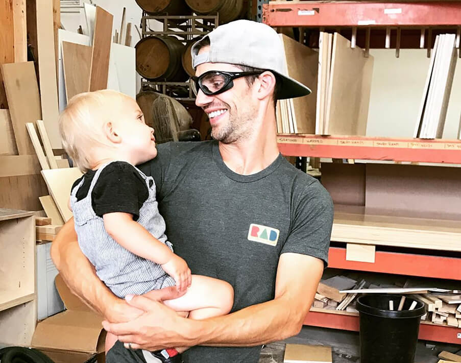 Man holding a baby in a workshop setting