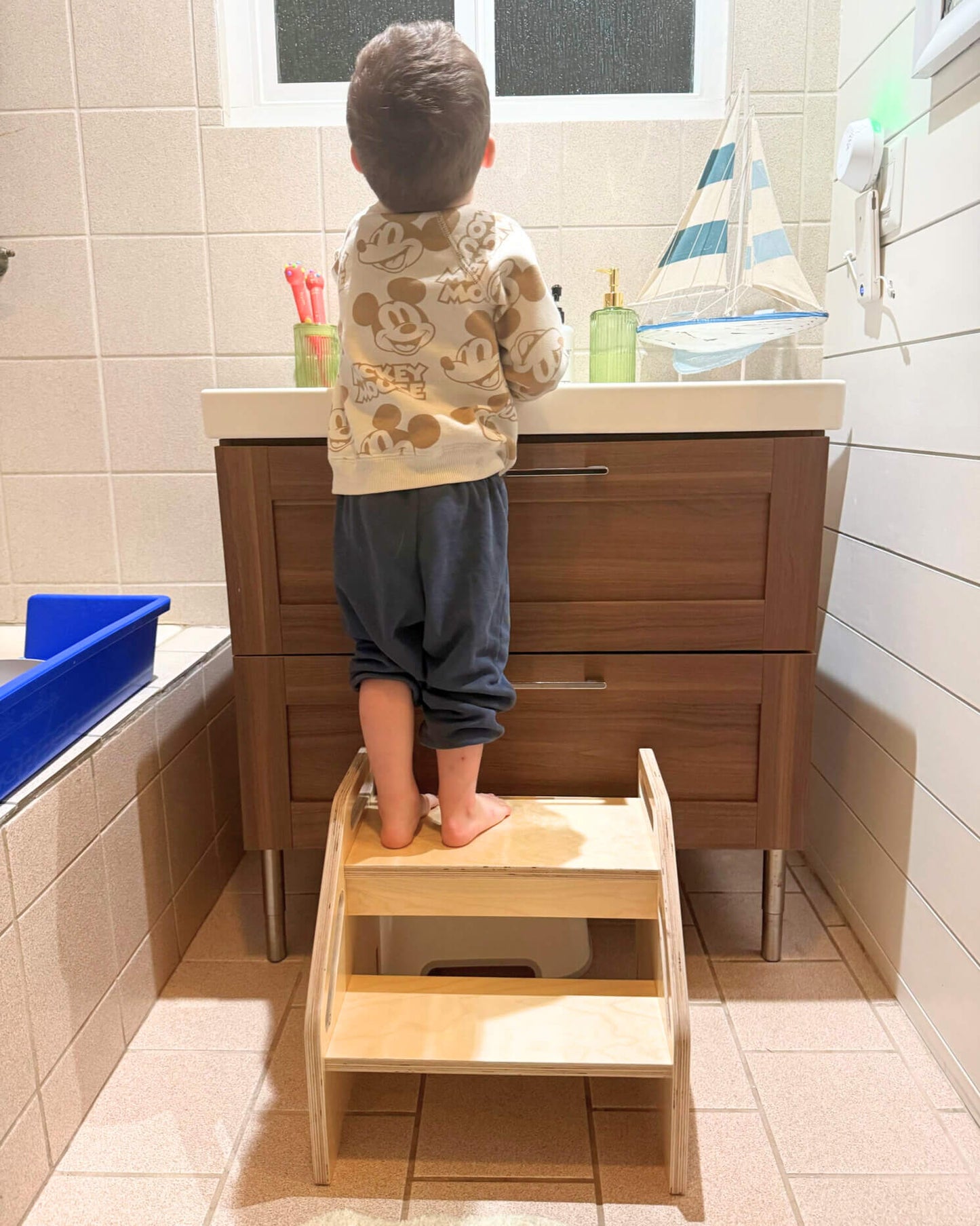 child on stepstool in bathoom