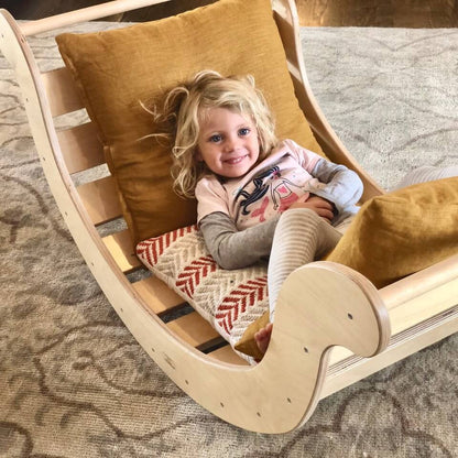 Child laying in jumbo rocker climber as a rocking chair.