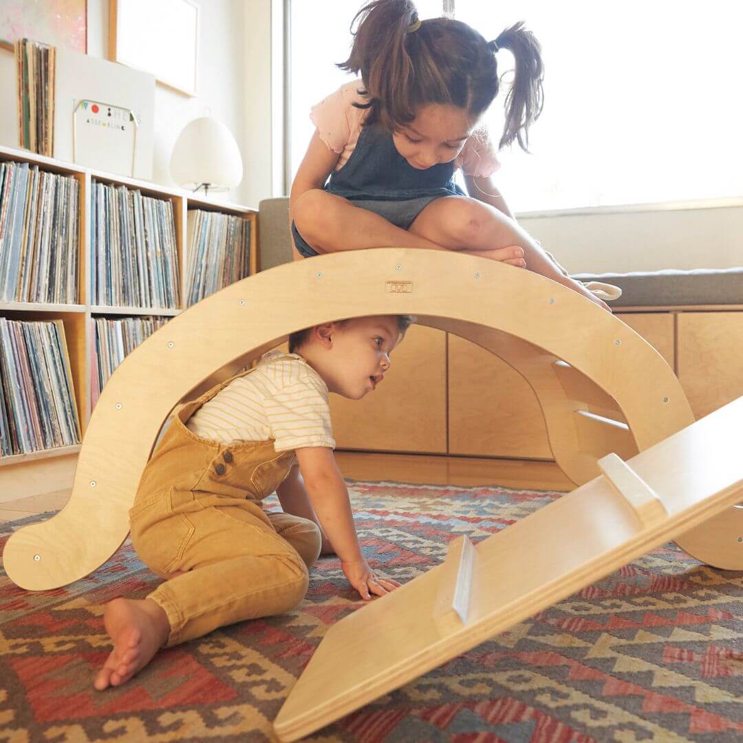 a little rocker climber in a playroom with two kids