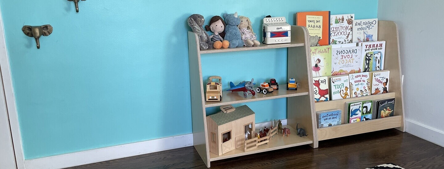 Children's bookshelf with toys and books against a blue wall