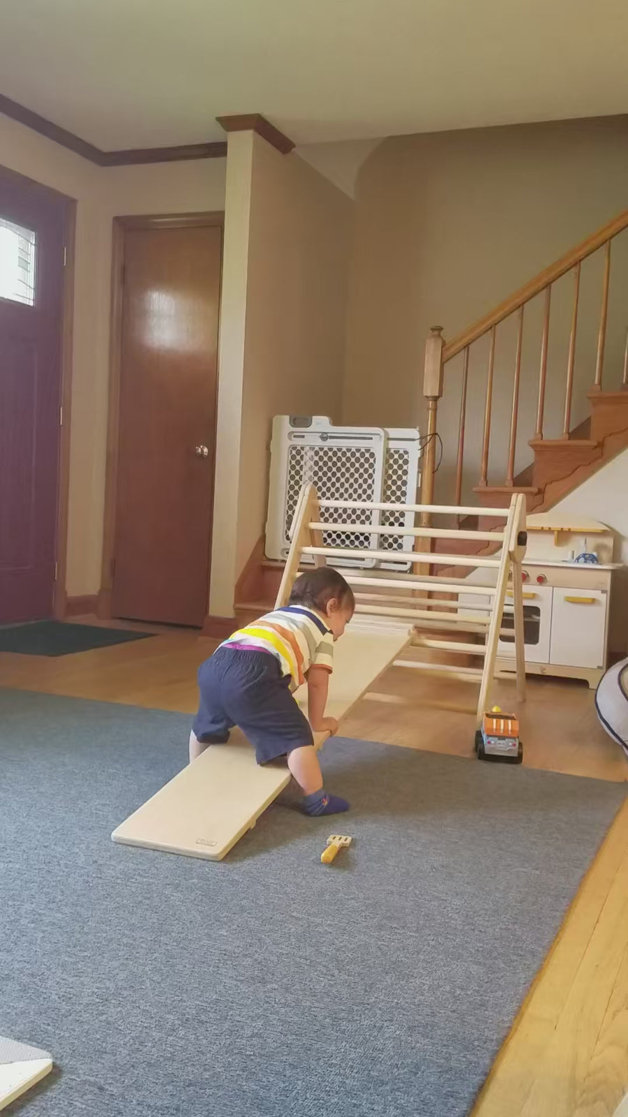 toddler climbing up slide on pikler triangle