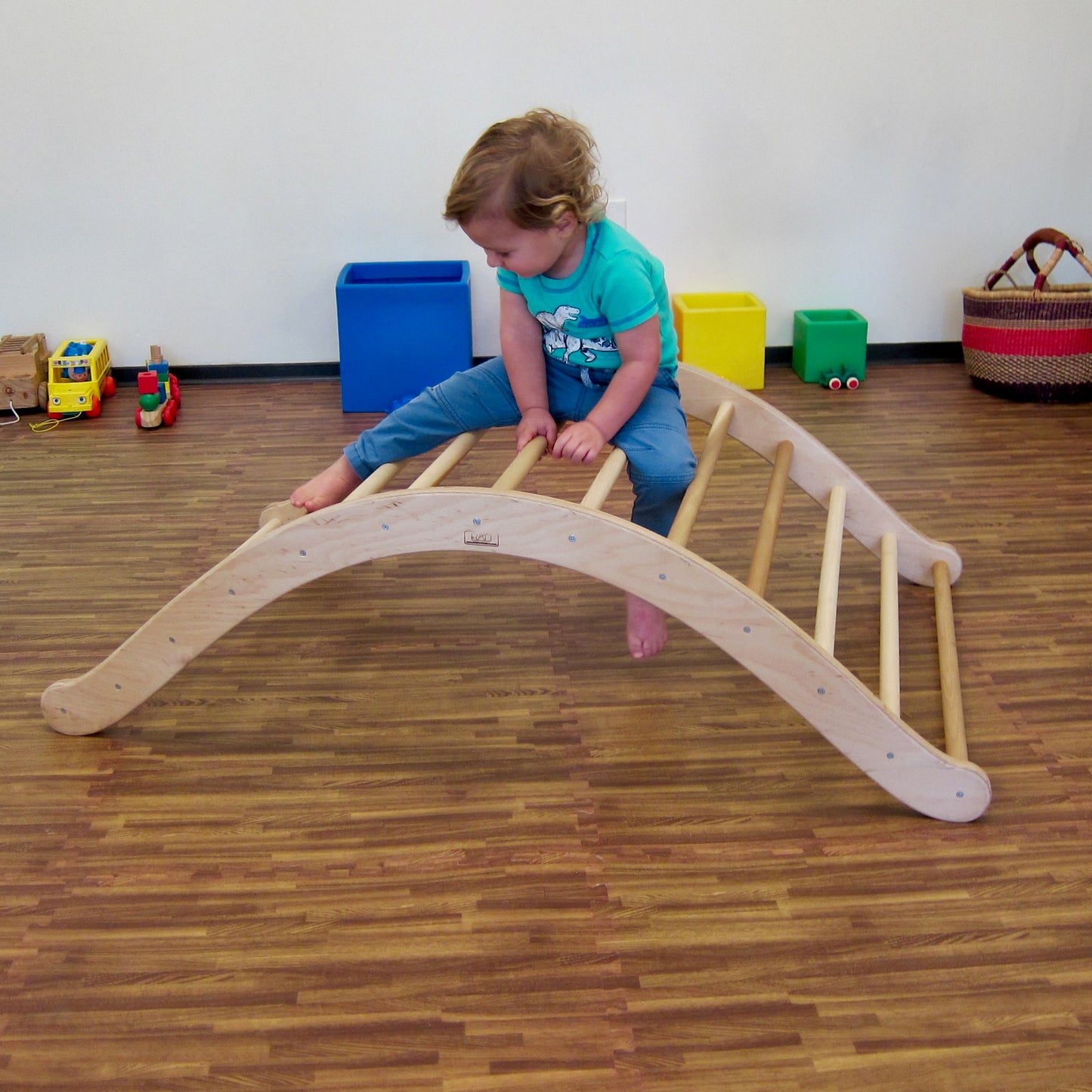 Boy on top of the climbing arch reaching his leg out to get to the next rung.